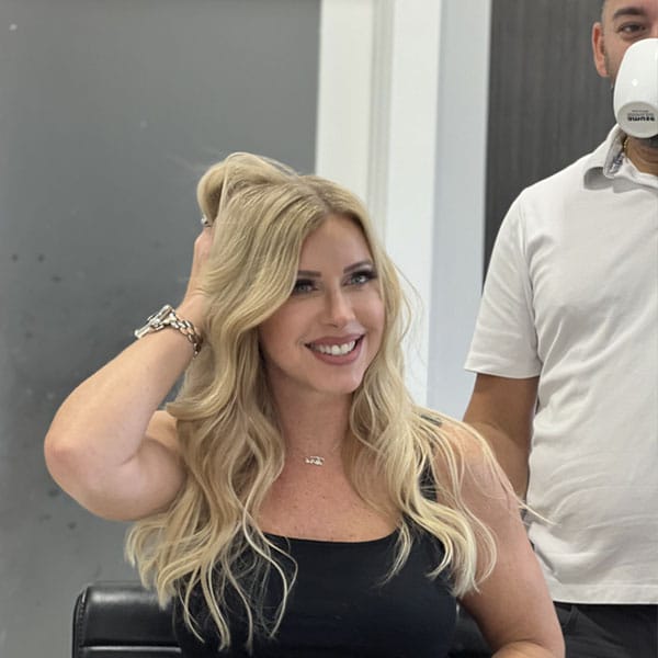 Stylist consulting with a client in a salon chair about her hair.